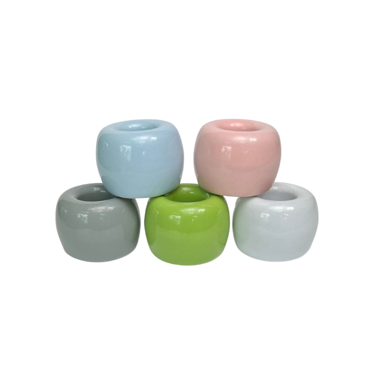 collection of 5 small ceramic toothbrush holders in glossy blue, grey, white, pink and white finishes