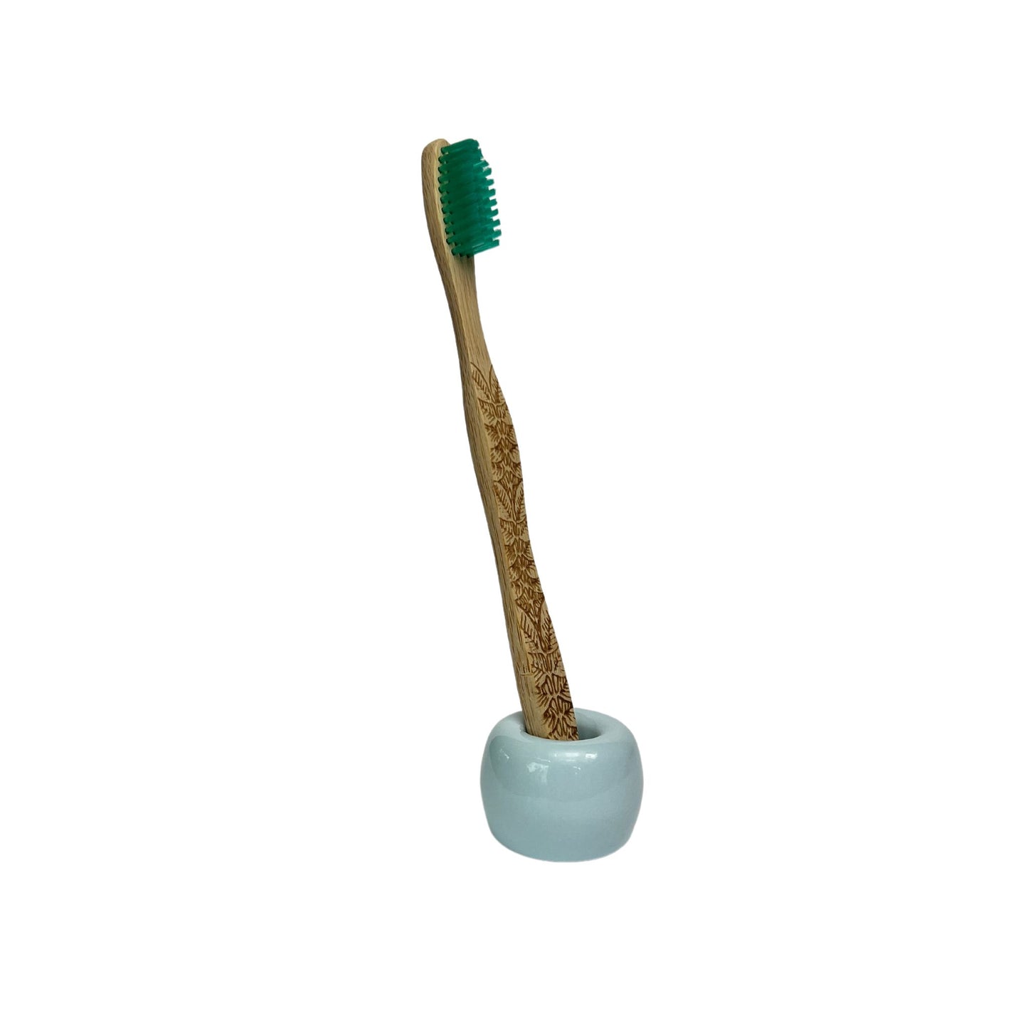 small ceramic toothbrush holder in glossy blue finish holding a bamboo toothbrush